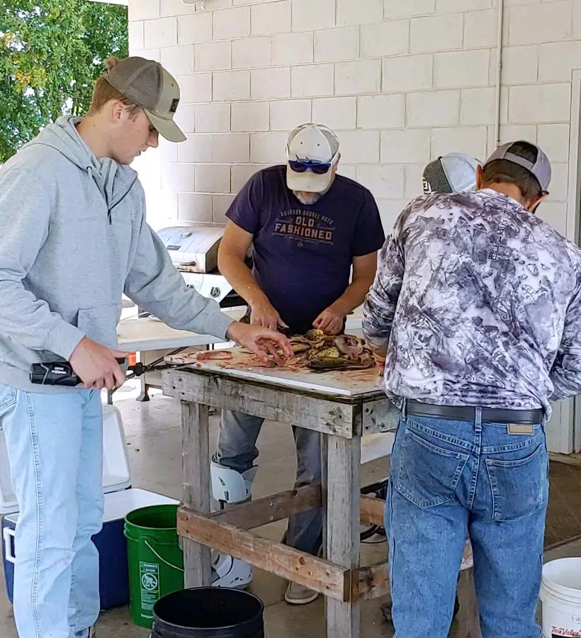 Watertown Rod and Gun Club members clean fish after a morning of fishing in the annual King Fish Classic